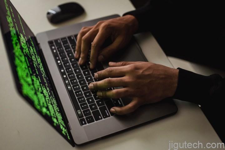 一个人使用笔记本电脑，显示屏上显示一组代码。